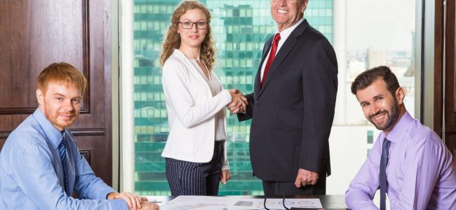 senior-business-man-smiling-while-shaking-hands-with-woman (1)