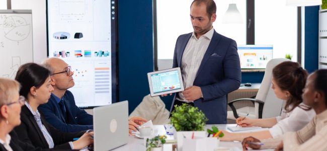 succesful-business-man-presenting-good-evolution-company-using-digital-tablet (1)