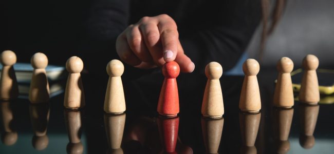 woman-showing-wooden-human-figures-recruitment-leadership (1)